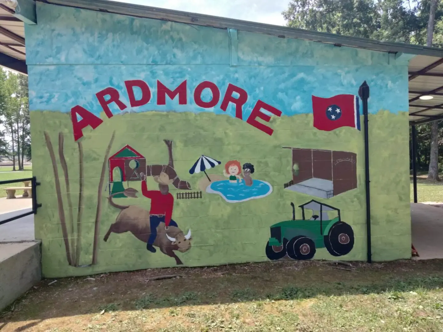 A mural of a boy riding a bull in front of a barn.