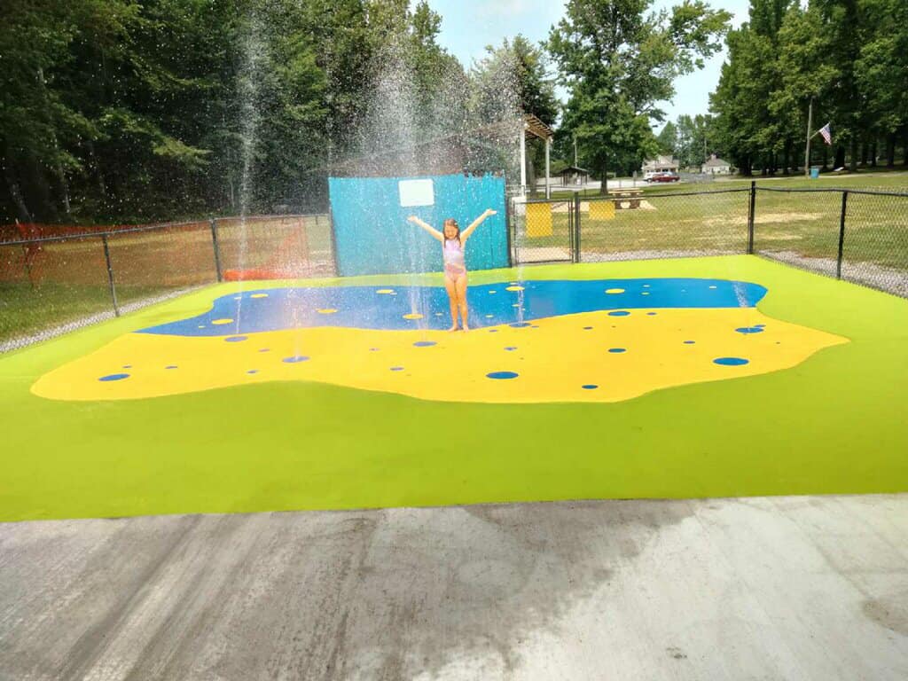 A person standing in the middle of an outdoor pool.